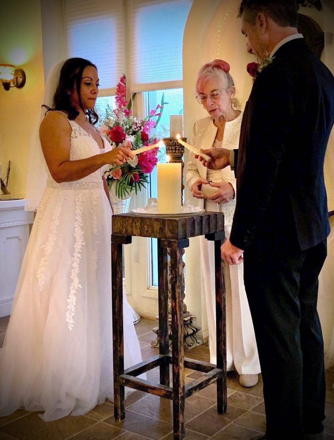 Bride and groom lighting a unity candle during their wedding ceremony.